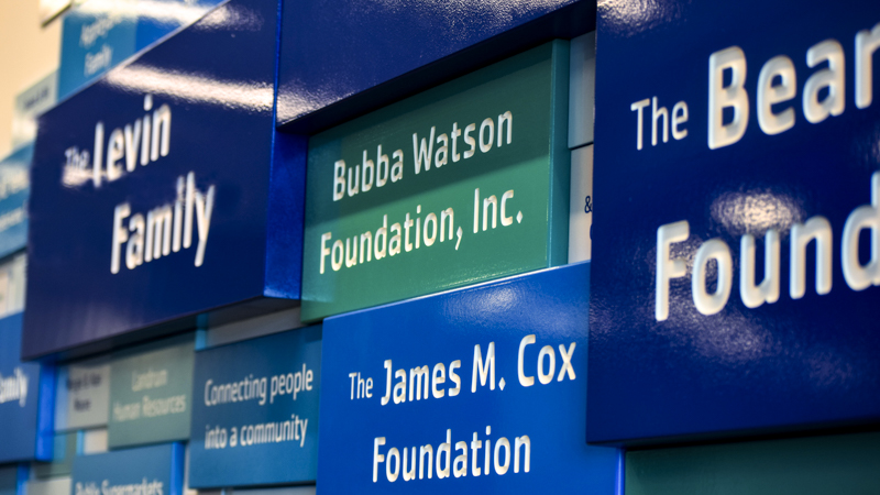 Donor display wall at YMCA Pensacola. Brand identity font and colors were used to create a fluid branded environment by signgeek