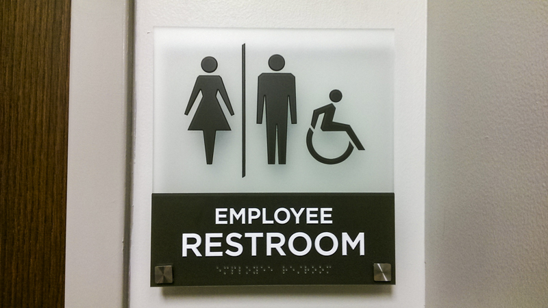 Interior ADA compliant restroom signage for Sacred Heart Health System. Fabricated and installed by Signgeek. 